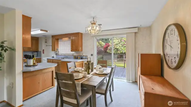 The dining area and kitchen effortlessly flow to the outdoor deck through sliding glass doors that also fill the space with natural light