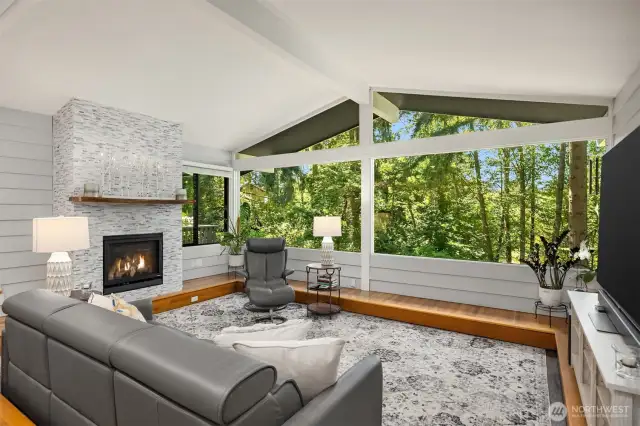The inviting living room features a cozy fireplace as its focal point and a picture window that frames