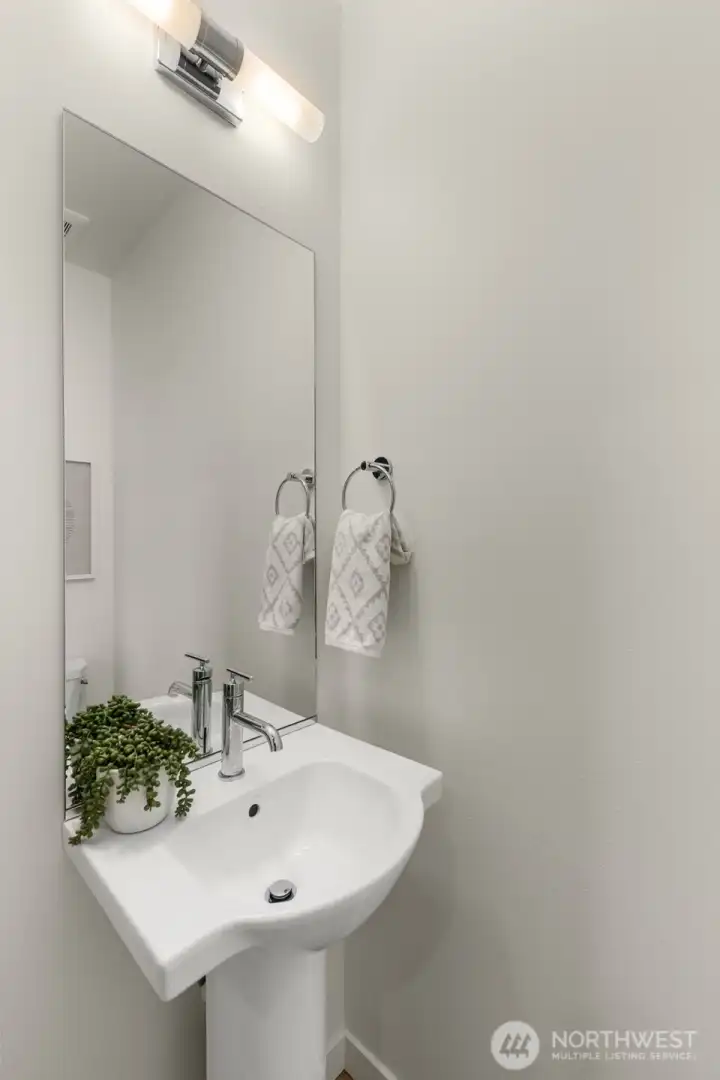 Sleek powder bath thoughtfully designed for guests, combining modern fixtures with a touch of elegance. Photos are of model home with similar fixtures & finishes.
