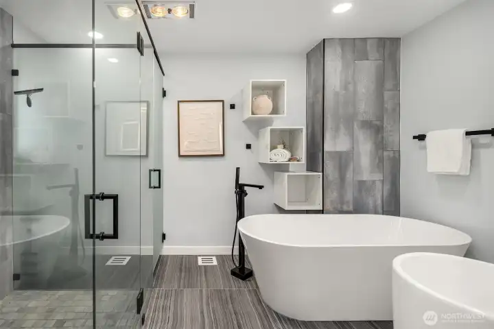 Spa bathroom for the primary suite: tiled floor, soaking tub, shower, separate toilet and dual sinks.