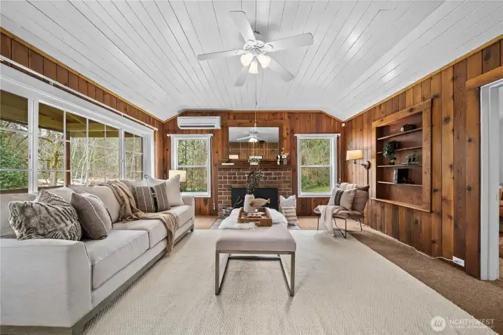 Gather around the warm wood fireplace while natural light pours in through oversized windows.