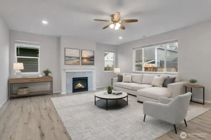 Cozy gas fireplace and a generous picture window make this living area inviting and light-filled  - Virtual stage.