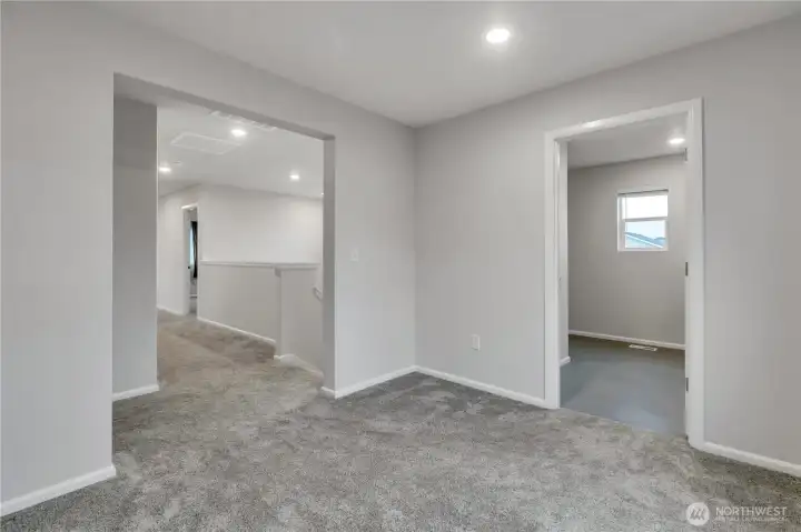 Bright den/office upstairs, with a doorway to the utility room just to the right.