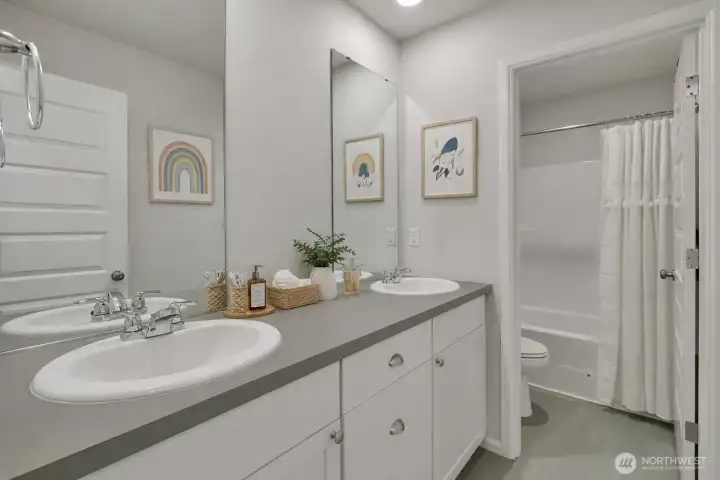 Upper-level bathroom designed with dual sinks and a separate water closet for comfort and privacy - virtual staged.