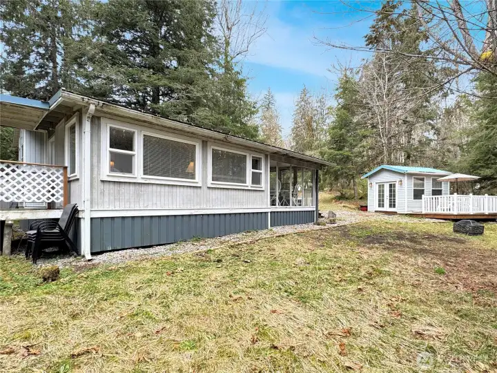 Side yard area adjacent to the park model with a view of the shed
