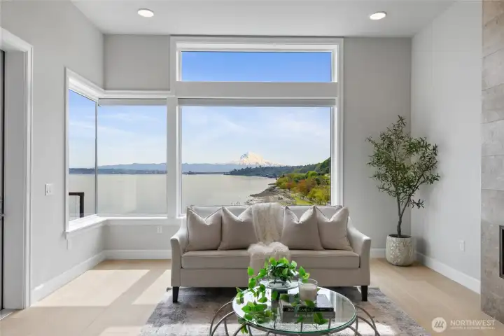 Mount Rainier takes center stage in the living room with cozy fireplace and breathtaking views