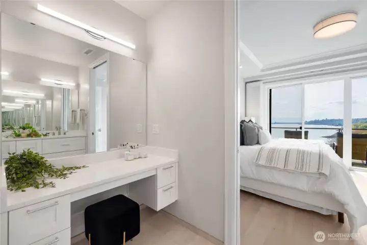 Spa-inspired primary bath with heated floors, double sinks, walk-in closet with custom built-ins, and dedicated vanity area