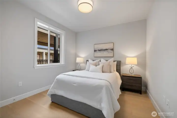 Bright second bedroom with high ceilings and generous closet space