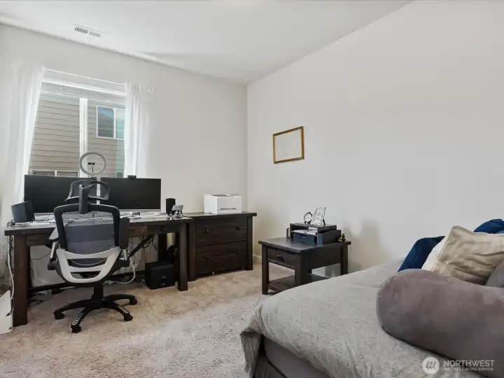 Main-floor flex room with a nearby shower bathroom offers flexible use as a guest room, office, or space for multigenerational living.
