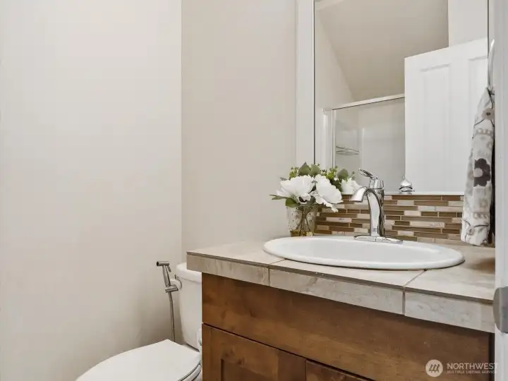 Shower bathroom on the main floor. Spacious shower stall is on the opposite side behind the door (shown in the mirror).