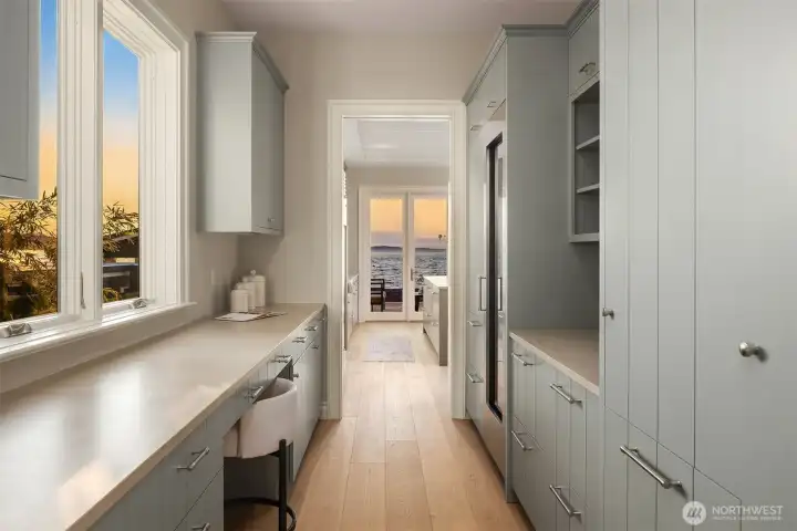 Conveniently located off the kitchen, this versatile pantry—with a wine refrigerator and abundant cabinetry—offers ample storage and can easily double as a built-in computer or command center.