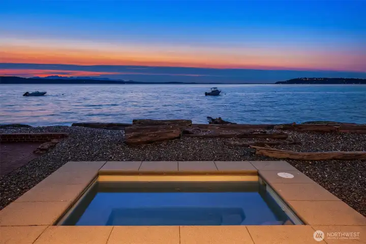 The spa Jacuzzi has been thoughtfully integrated into the landscape, blending effortlessly with the natural shoreline and elevating the rare beauty of this exceptional waterfront setting.