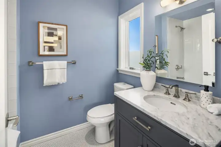 An adjoining full bath with a clean, refreshing, and timeless appeal.