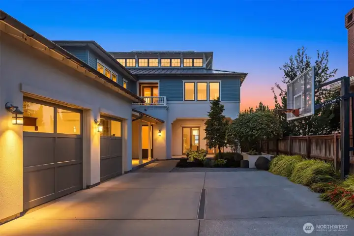 From the street side, the home presents the same impressive coastal lines and refined architectural details while maintaining a discreet sense of privacy. A large three-car garage with full-length overhead storage, complemented by generous guest parking, offers a rare level of convenience for a beachfront estate.