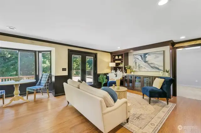 This family room off of the kitchen has beautiful built in cabinetry, solid hardwood flooring, and French doors to the trex deck that runs the length of the entire home.