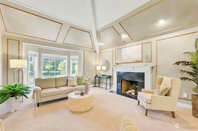 Lovely living room has soaring ceilings & a cozy wood fireplace.