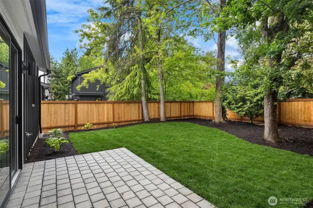 Large, flat landscaped and fenced yard with patio