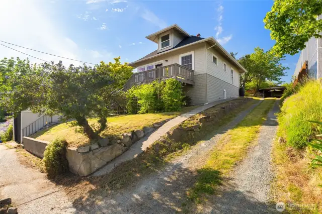 West driveway for extra parking extends to the back of the property and a carport and storage shed.