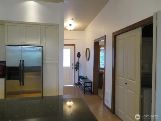 View from kitchen towards entry. Utility closet with stacking washer and dryer shown to the right.