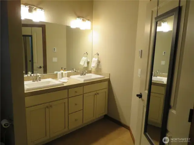 Primary bath has double sinks shown.  Light white cabinetry.