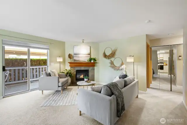 Living area with electric fireplace and light filled slider to covered patio