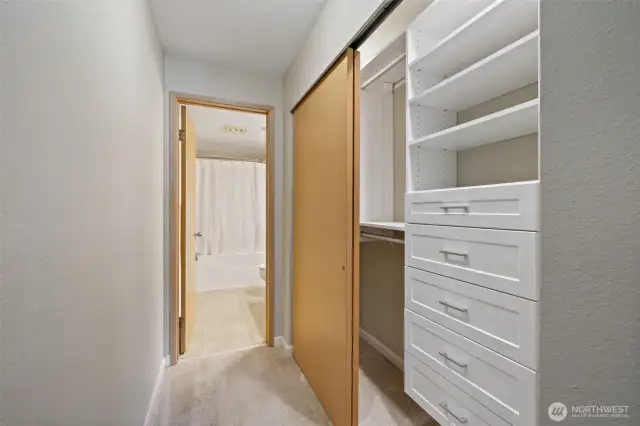 Hallway to primary bath, lighted closet with California closets