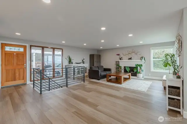 Beautiful flooring at the entry extends throughout the main living areas. A sleek white-bricked fireplace adds charm and ambiance in the living room.