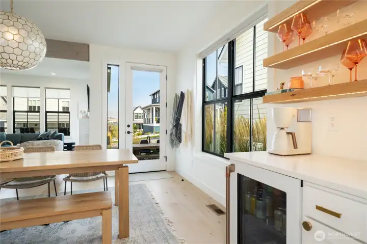 Beverage bar, open shelving, accent lighting, backlit bevy fridge and a quartz counter top.