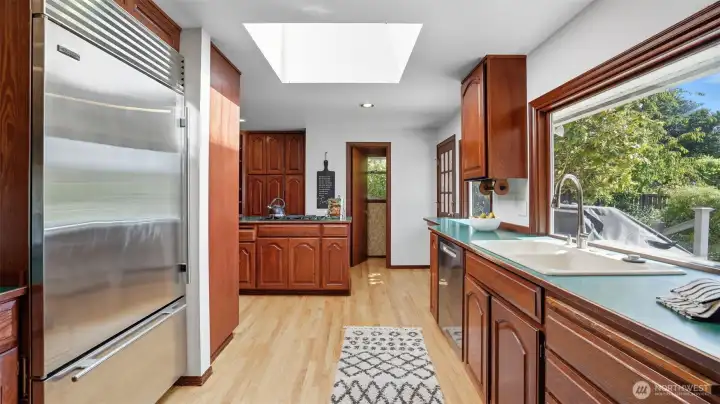 Skylight and oversized windows bathe the kitchen in natural light.