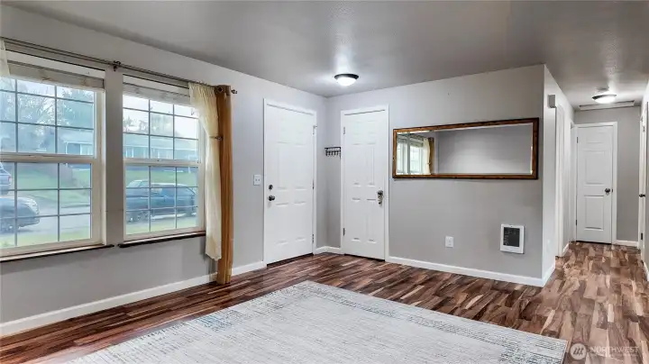 Bright living room with large windows, updated flooring, and a functional open layout.