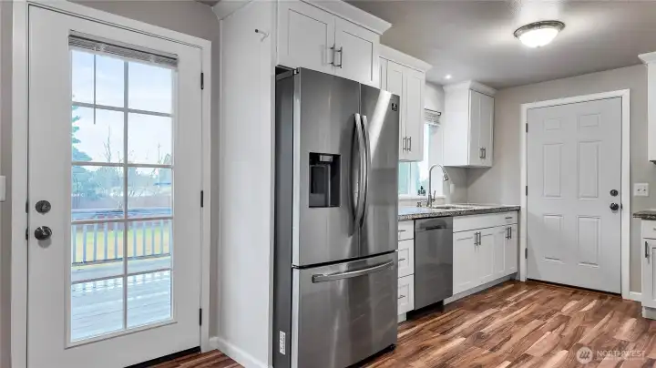Kitchen with deck access featuring stainless steel appliances and easy indoor outdoor flow.