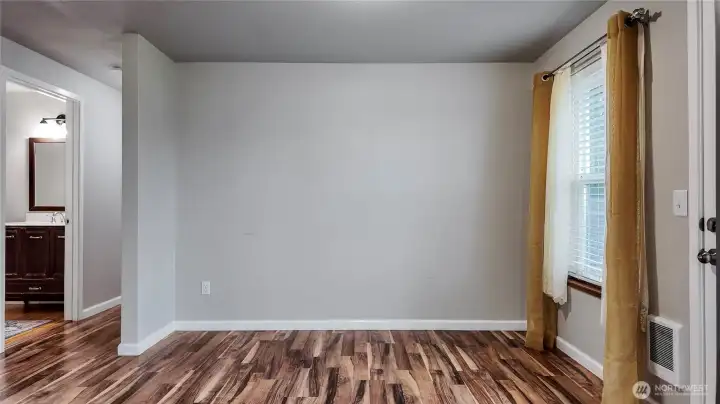 Dining space with updated flooring and natural light from the window.