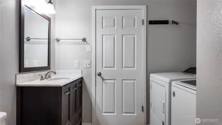 Bathroom and laundry area with updated vanity, stone countertop, and convenient washer and dryer setup. *Washer & Dryer not included*