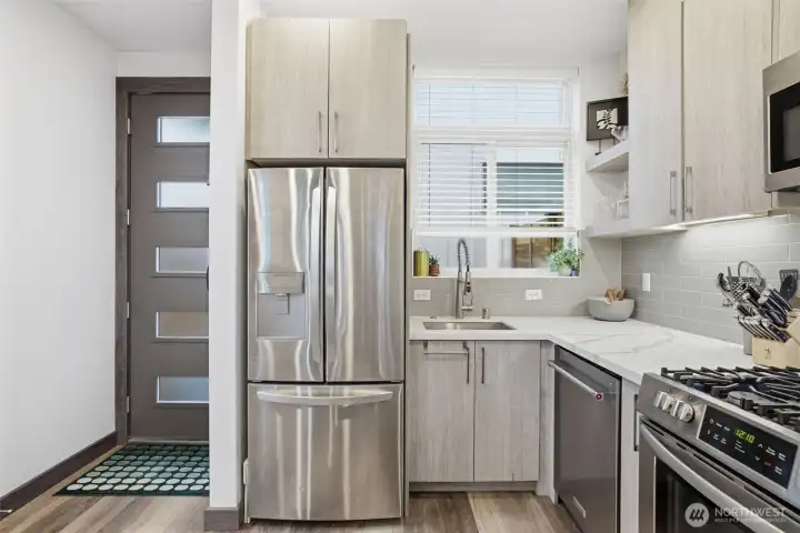 Thoughtfully designed kitchen featuring sleek cabinetry, tile backsplash, and efficient use of space.