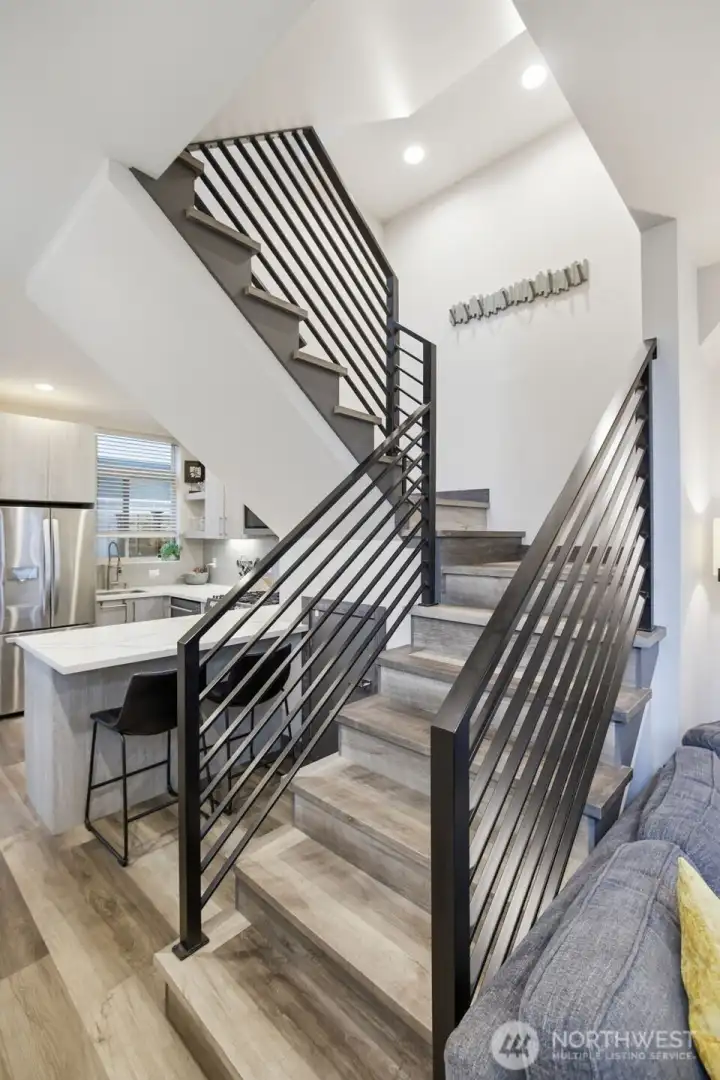 Contemporary staircase with metal railing detail adds architectural interest and connects multiple levels.