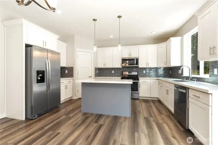 Gas range -Room for  casual eating spaces on Island. Quartz countertops, all stainless appliances.