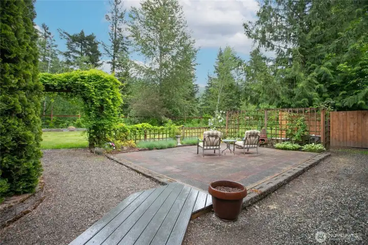 Large patio and the archway leads to a huge yard