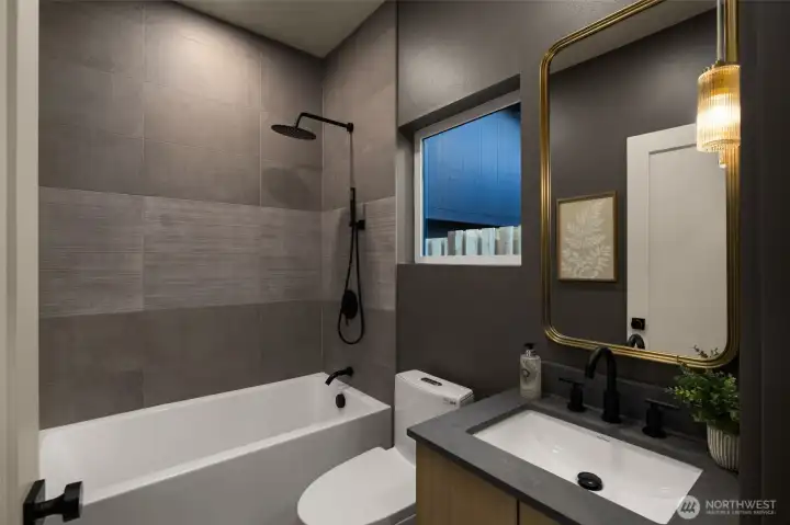 Additional full bath featuring a deep soaking tub and sleek horizontal tiling.