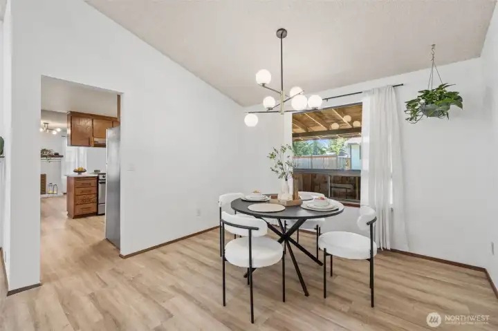 Dining area just off the kitchen features a striking modern light fixture that adds warmth and style.