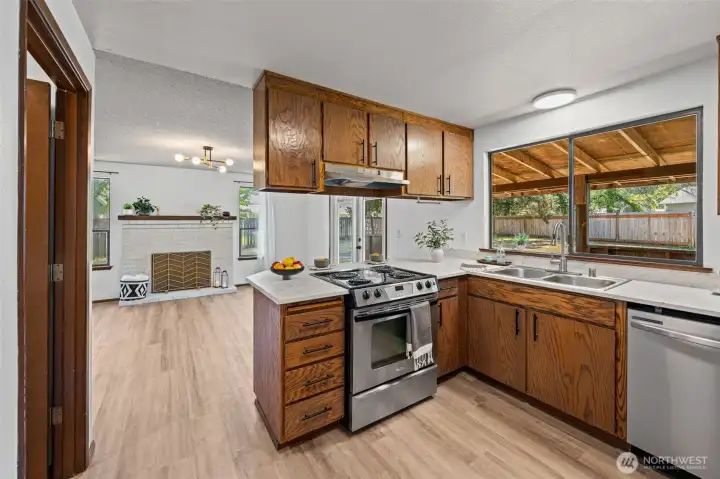 Updated kitchen opens seamlessly to the family room, where the original wood-burning fireplace adds timeless character.