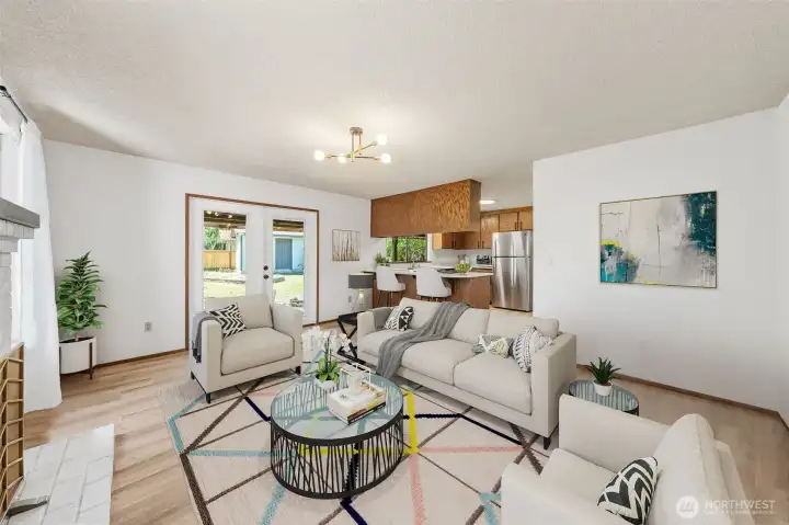 Cozy family room with double doors leading to the backyard creates effortless indoor-outdoor living. (Virtually Staged)