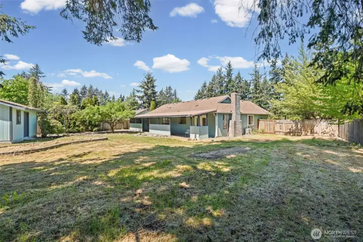 From the far corner of the yard, you can truly appreciate the covered outdoor living area stretching along the back of the home.