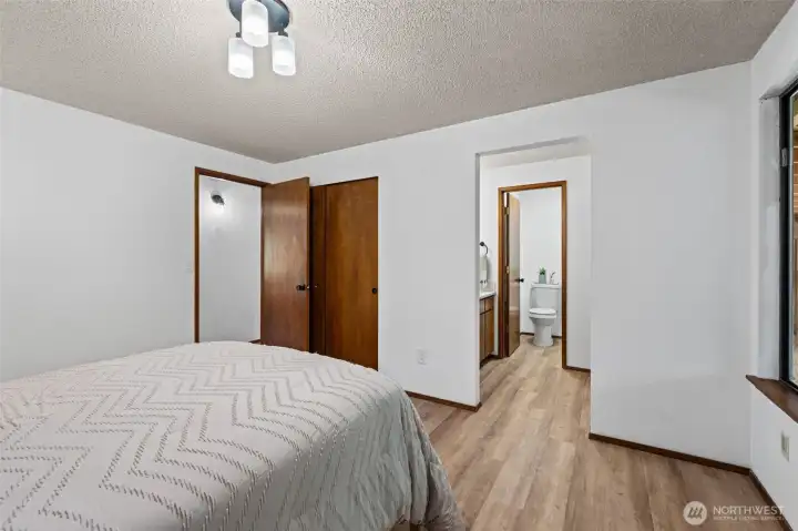 Functional primary suite layout includes a dedicated sink area with convenient passthrough access to the shower and toilet area.