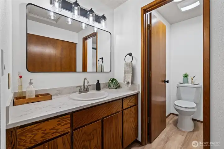 Freshly updated vanity area with new counters, fixtures, mirrors, and hardware gives the space a clean, modern feel.