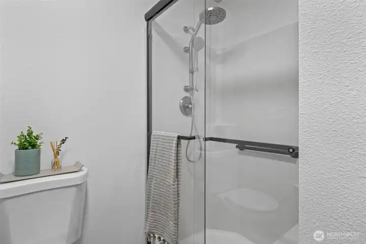 Brand new shower doors and toilet complete the refreshed primary bath.