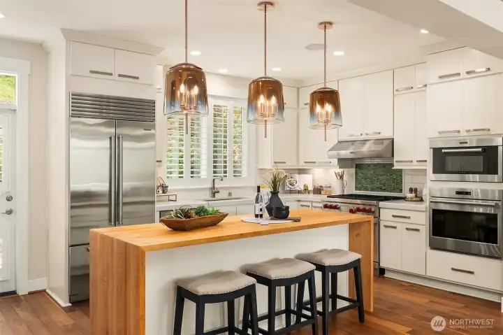 The heart of the home is defined by exceptional craftsmanship. A handcrafted butcher block waterfall island anchors the space, while full-height custom cabinetry, artisan tile, sculptural pendant lighting, and a professional Wolf and Sub-Zero appliance suite create a kitchen that's as timeless as it is functional. The heart of the home is defined by exceptional craftsmanship. A handcrafted butcher block waterfall island anchors the space, while full-height custom cabinetry, artisan tile, sculptural pendant lighting, and a professional Wolf and Sub-Zero appliance suite create a kitchen that's as timeless as it is functional.