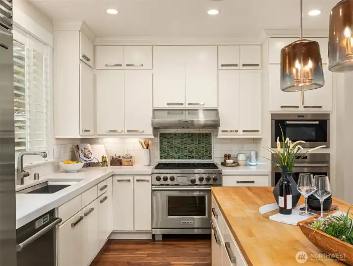 A study in thoughtful craftsmanship. The warmth of the handcrafted butcher block waterfall island is complemented by tailored cabinetry, professional Wolf and Sub-Zero appliances, and a handcrafted artisan tile backsplash whose rich texture and organic tones create a striking focal point behind the range. A study in thoughtful craftsmanship. The warmth of the handcrafted butcher block waterfall island is complemented by tailored cabinetry, professional Wolf and Sub-Zero appliances, and a handcrafted artisan tile backsplash whose rich texture and organic tones create a striking focal point behind the range.