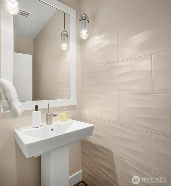 Simple, elegant, and beautifully executed, the main-floor powder room combines sculptural textured tile with contemporary fixtures to create a refined space with lasting visual impact. Simple, elegant, and beautifully executed, the main-floor powder room combines sculptural textured tile with contemporary fixtures to create a refined space with lasting visual impact.