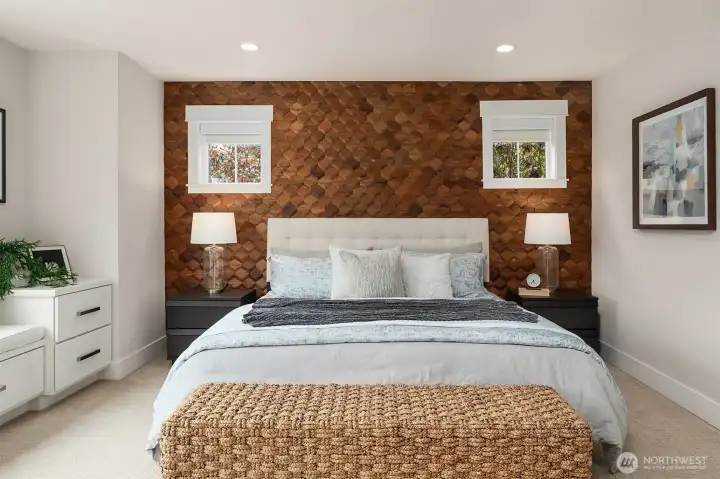 A dramatic custom wood feature wall showcases geometric craftsmanship and rich natural tones, creating an elegant focal point that elevates the peaceful ambiance of the primary suite. A dramatic custom wood feature wall showcases geometric craftsmanship and rich natural tones, creating an elegant focal point that elevates the peaceful ambiance of the primary suite.