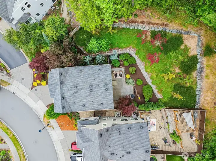 A bird's-eye view reveals the home's beautifully designed outdoor spaces, where expansive patios, professionally landscaped grounds, and substantial terraced stone retaining walls blend seamlessly into a lush natural greenbelt, creating an exceptional sense of privacy rarely found in newer construction. A bird's-eye view reveals the home's beautifully designed outdoor spaces, where expansive patios, professionally landscaped grounds, and substantial terraced stone retaining walls blend seamlessly into a lush natural greenbelt, creating an exceptional sense of privacy rarely found in newer construction.